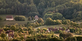 Das Museumsgelände aus der Entfernung. Viele alte Häuser und zahlreiche grüne Bäume und Wiesen